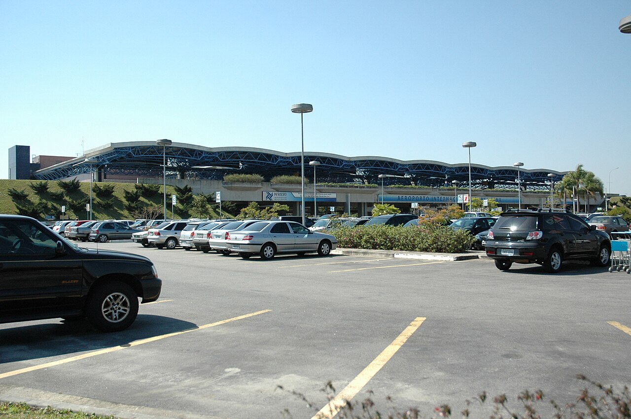 Imagem ilustrativa: Fachada do Aeroporto Internacional Afonso Pena, com o estacionamento em primeiro plano