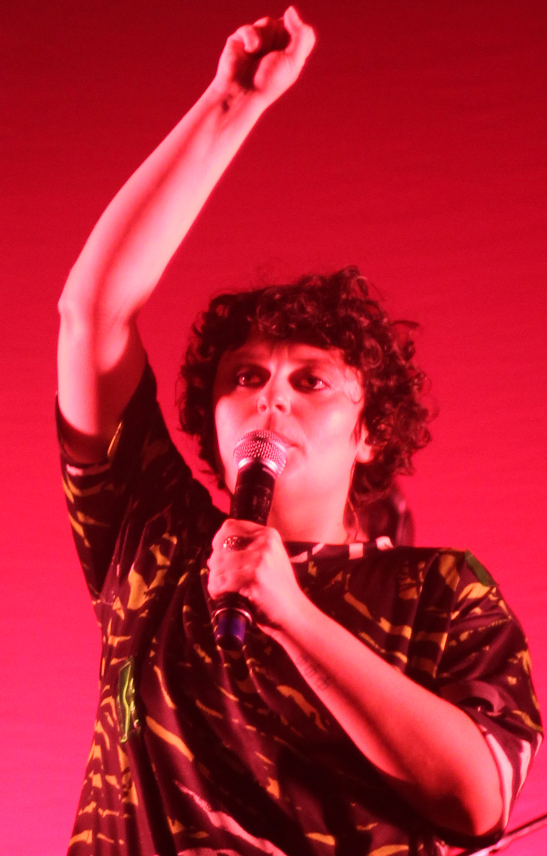 Imagem ilustrativa: Ana Frango Elétrico canta ao microfone em show no Circo Voador, em janeiro de 2024, sob luz vermelha