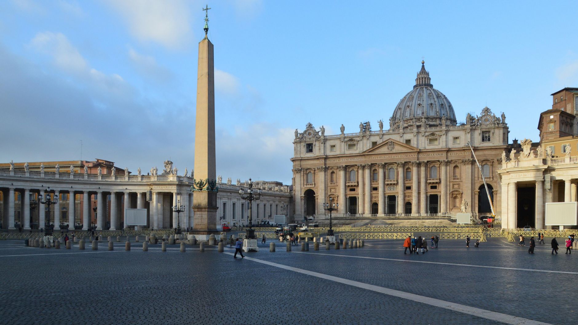 Imagem ilustrativa: Vista da Cidade do Vaticano com a Basílica de São Pedro, obelisco e colunatas em um dia ensolarado.