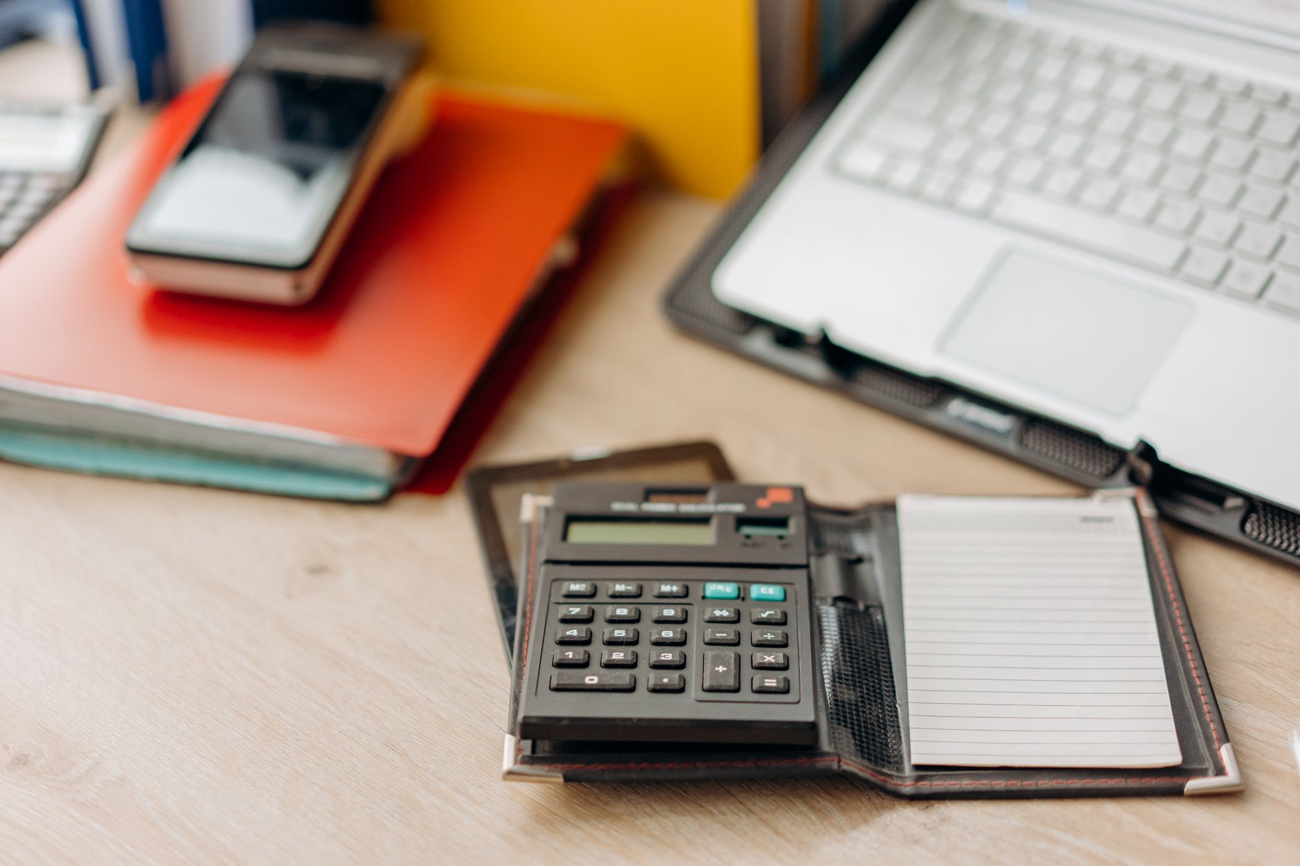 Imagem ilustrativa: Organized workspace featuring a calculator, notepad, and laptop. Perfect for productivity themes.
