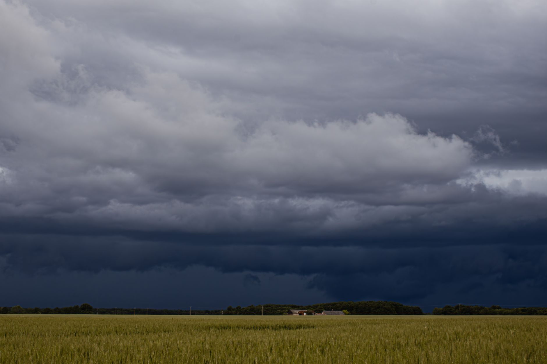 Imagem ilustrativa: Um céu escuro e ameaçador, com nuvens de tempestade, paira sobre uma paisagem rural.