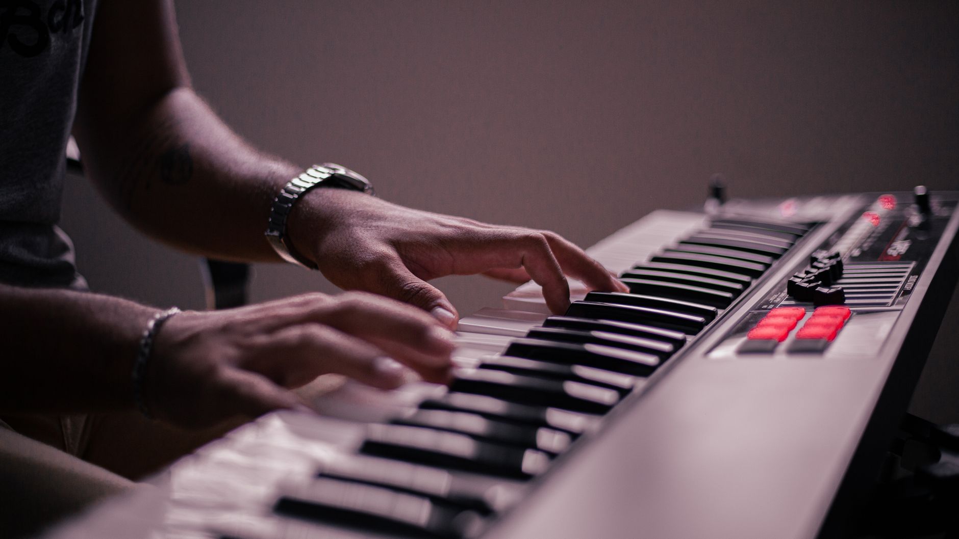 Imagem ilustrativa: Mãos tocando um teclado eletrônico, em detalhe.
