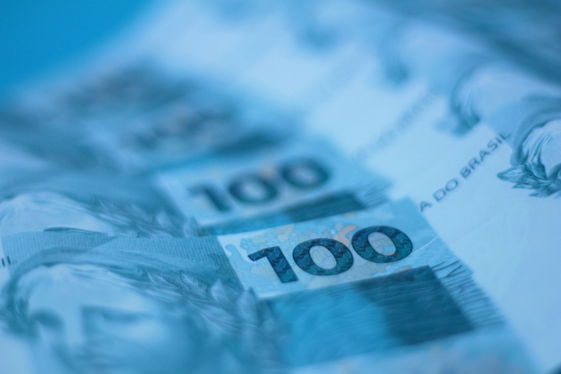 Imagem ilustrativa: Close de notas de 100 reais brasileiras, com detalhe da cédula.