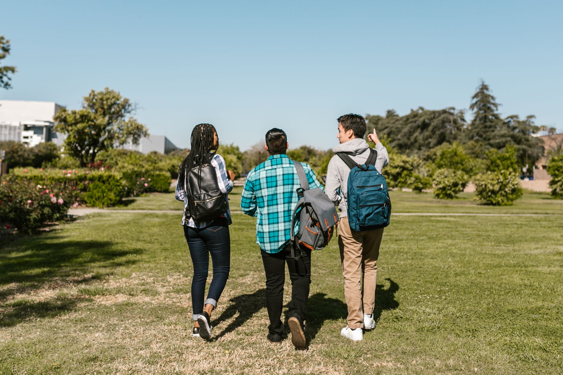 Imagem ilustrativa: Grupo de estudantes universitários caminhando juntos ao ar livre em um dia ensolarado, com mochilas e roupas casuais.
