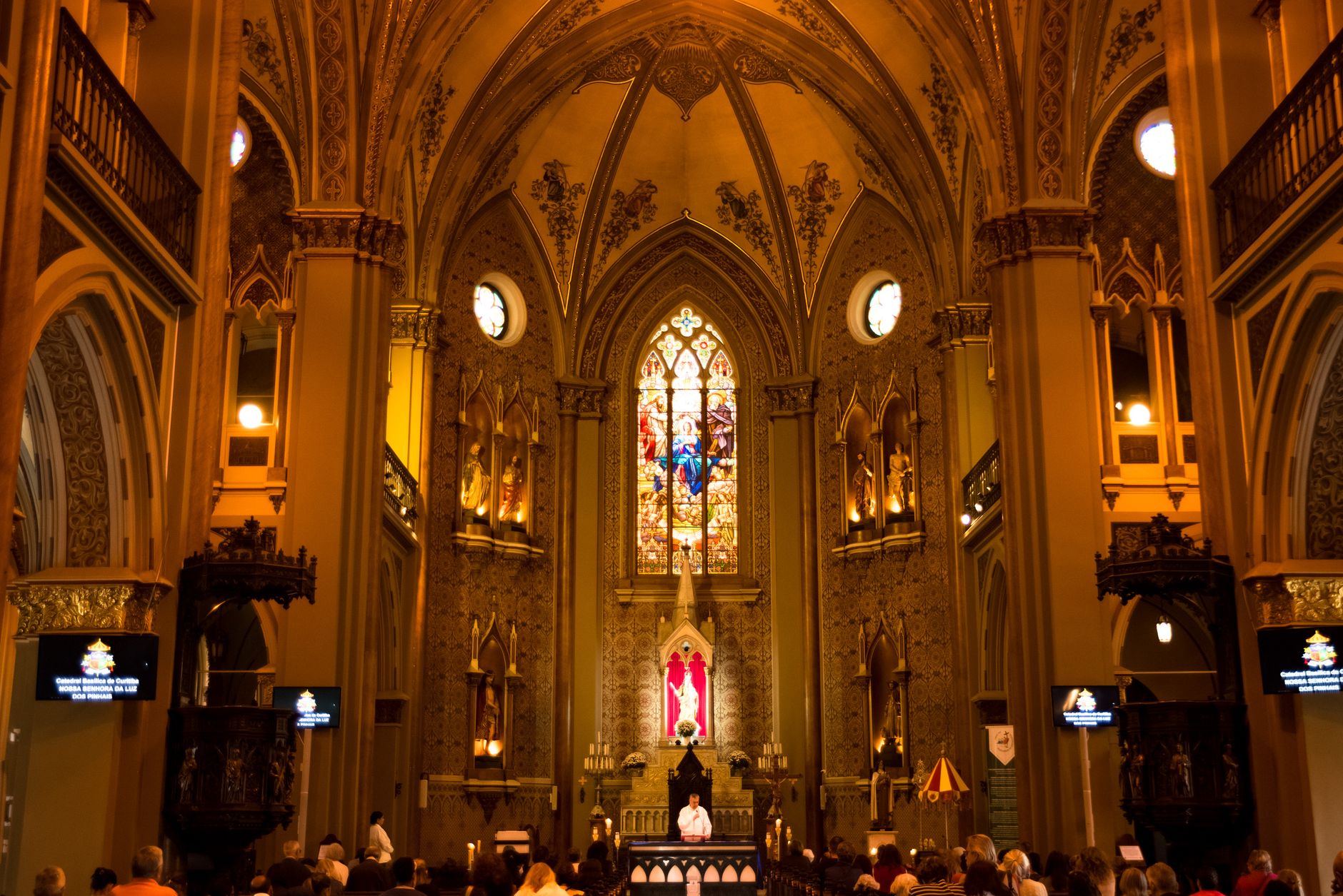 Imagem ilustrativa: Interior de basílica histórica em Curitiba, com vitrais e detalhes arquitetônicos.