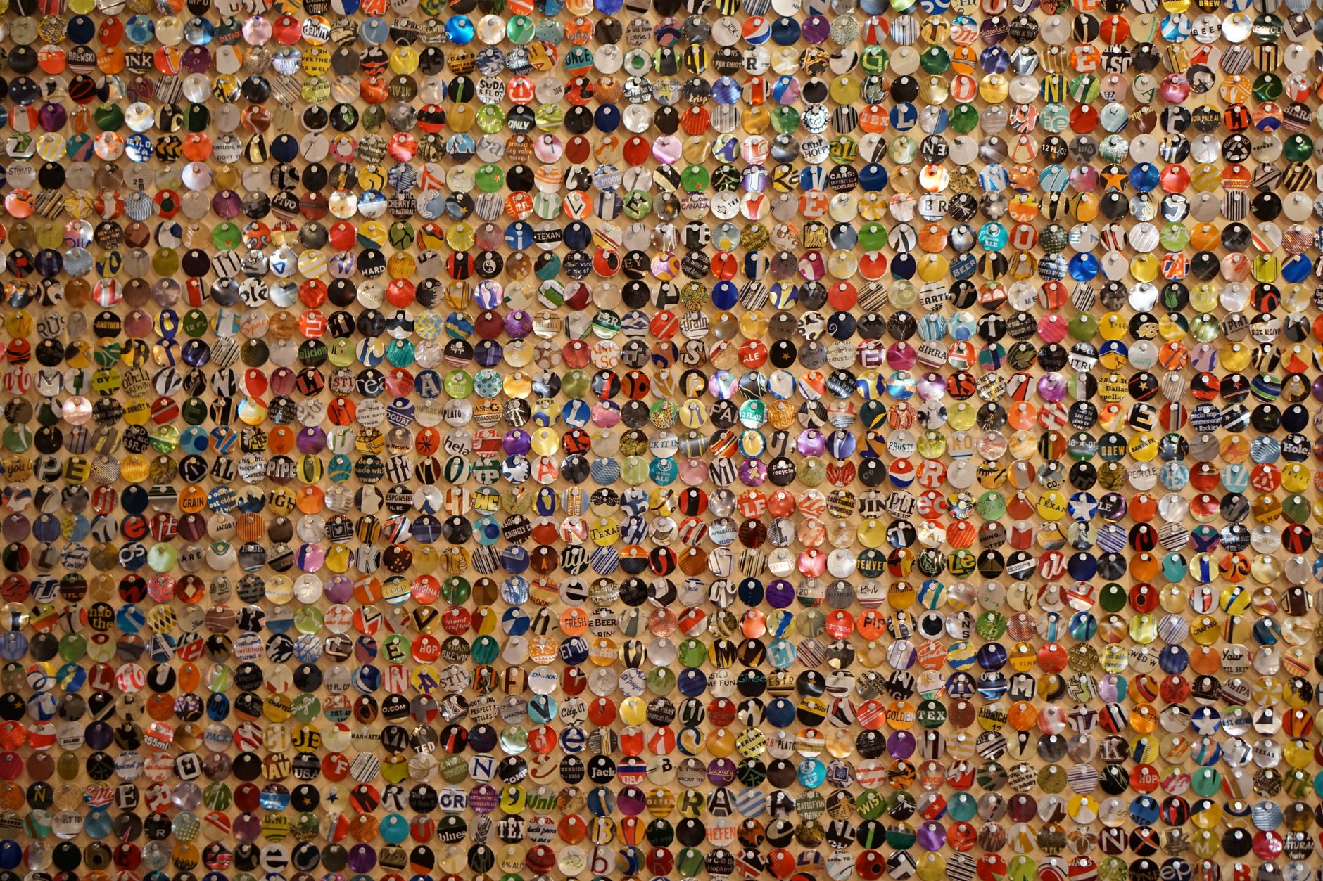 Imagem ilustrativa: Painel formado por centenas de tampinhas coloridas, exemplo de arte feita com material descartado.